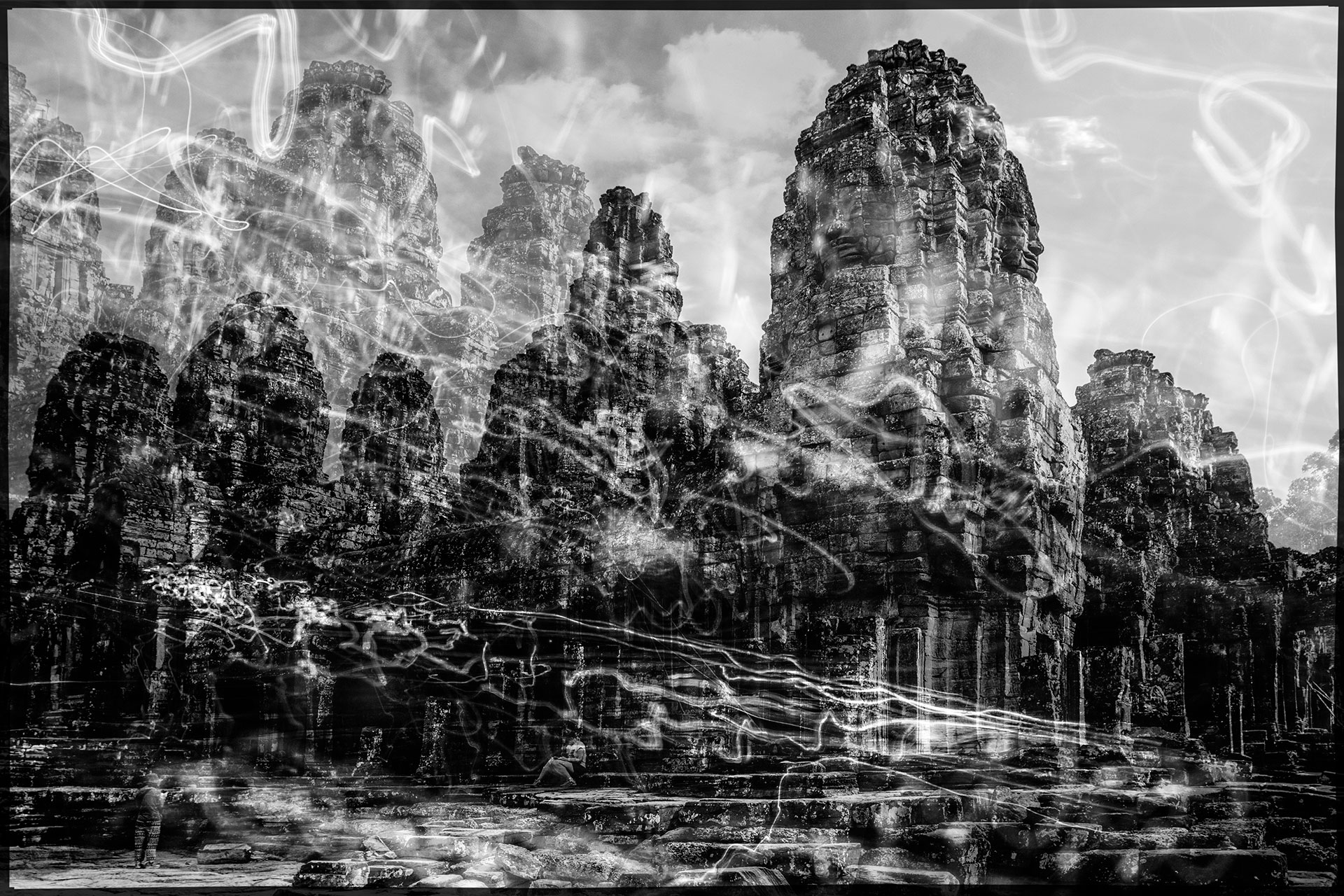 A temple monument from the Angkor Wat complex in a gloomy black-and-white backdrop. Crossing traces of light are essential design element of artistic photography.